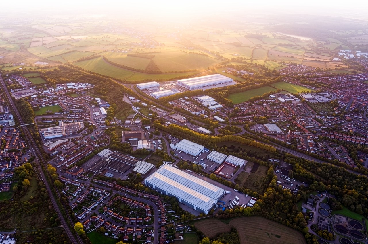 Aerial view at sunrise looking north-west over Langley Mill. Langley 255 is outlined in yellow beside the A610, with nearby occupiers labelled: Wernick, ASDA, Lidl, two Bidfood sites, CCF, two Warburtons sites, Evri, Greene King and Amazon, and arrows along the A610 to M1 Junction 26 (5 miles) and Nottingham